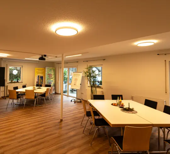 The common room of a care home with large, round lights on the ceiling