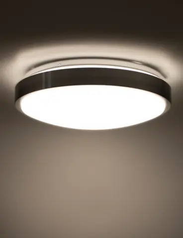 A round, white ceiling light in a dark room