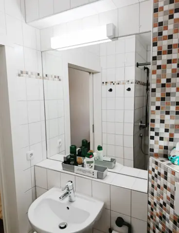 A bathroom with a bright LED light above the mirror