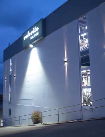 The Velovita bike shop at dusk, with its outdoor lighting switched on