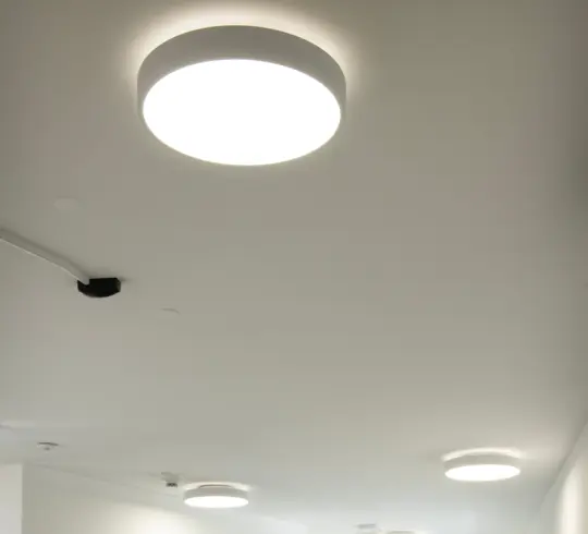 The corridor of a care home with large, round ceiling lights