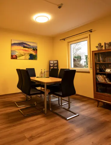 The common room of a care home with large, round lights on the ceiling