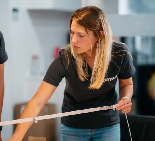 Eine Frau mit langen blonden Haaren hält eine QUICK-FIXdc in der linken Hand