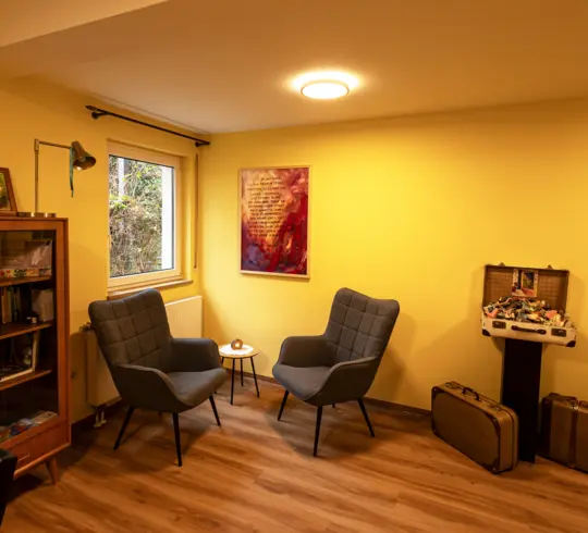 The common room of a care home with large, round lights on the ceiling