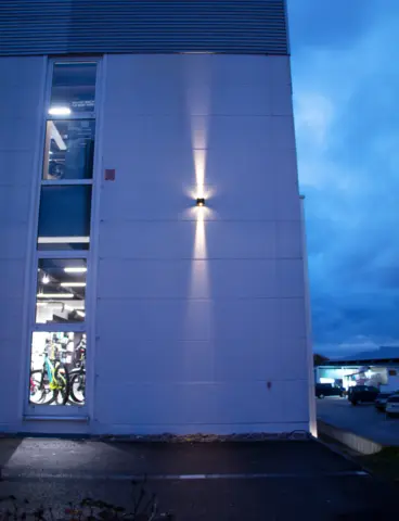 The Velovita bike shop at dusk, with its outdoor lighting switched on