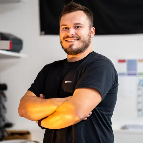 A smiling man with his arms crossed