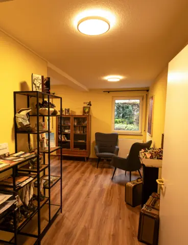 The corridor of a care home with large, round lights on the ceiling
