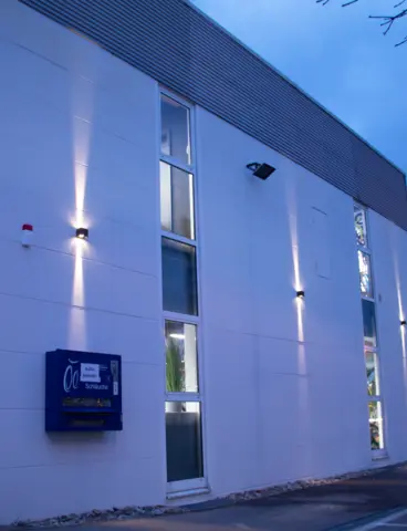 The Velovita bike shop at dusk, with its outdoor lighting switched on