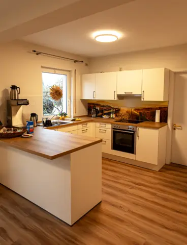 The kitchen of a care home with large, round lights on the ceiling