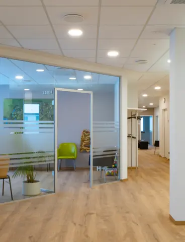 The waiting room of a doctor’s surgery, separated by a glass partition