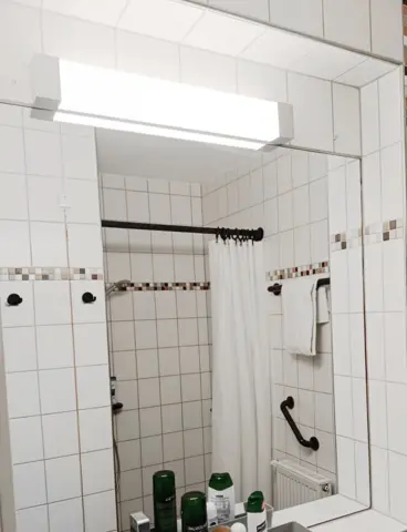 A bathroom with a bright LED light above the mirror