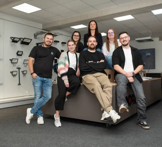 Eine Gruppe von Mitarbeitern sitzt in einem Showroom